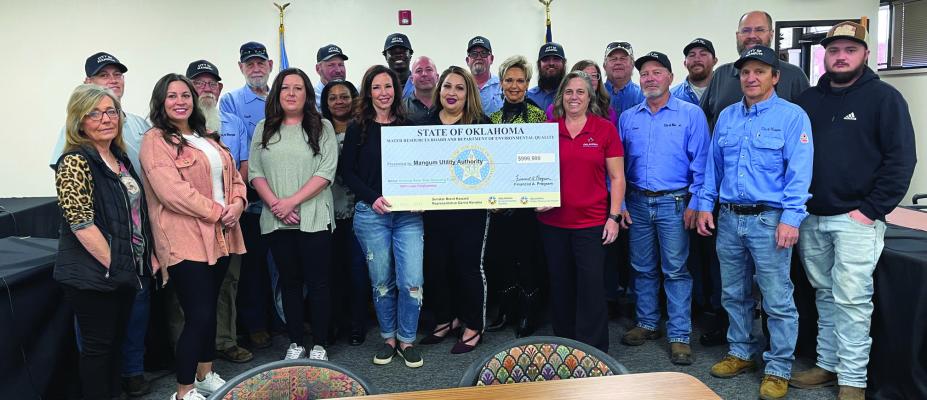 City workers and staff join the mayor, council members and other City representatives for the check presentation last Thursday that will be used to install new automatic remote meters in Mangum.