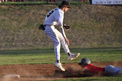 An errant throw forces Shortstop Jaxson Wade to avoid a slide into second base by a Merritt player.